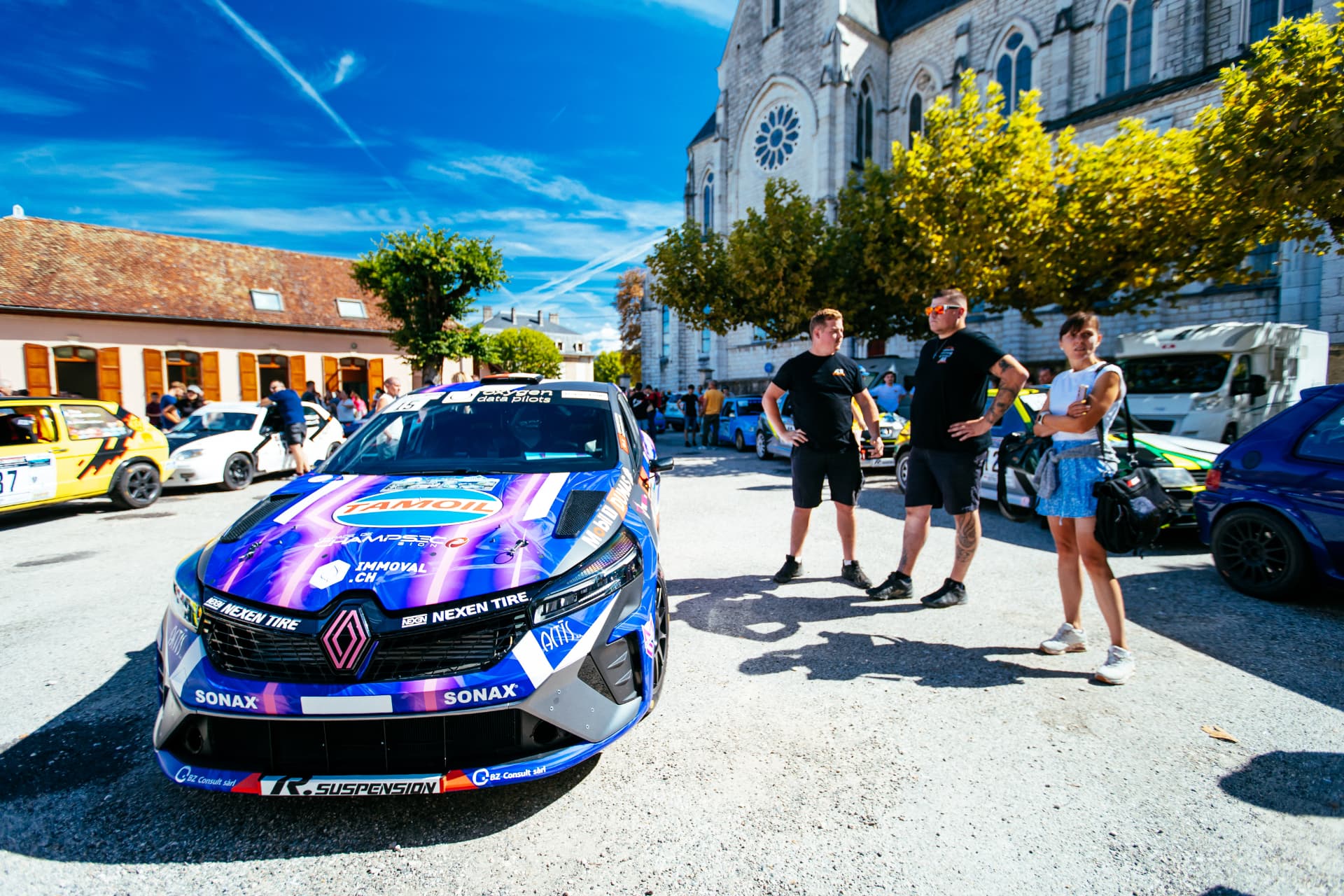 Face avant de la Clio Rally3 sur la place du village, capot Tamoil