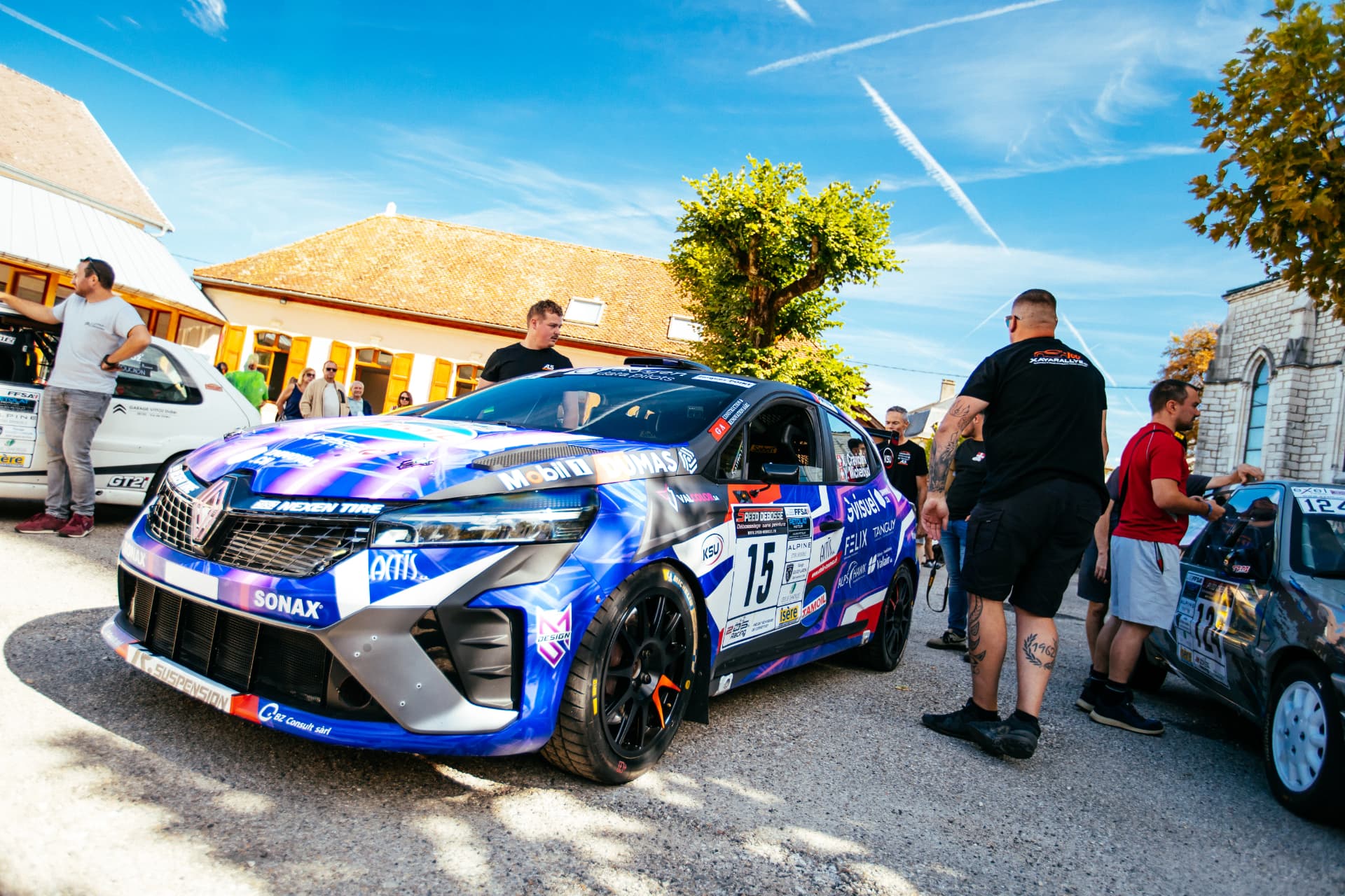La Clio Rally3 n°15 dans les rues du village avant le départ