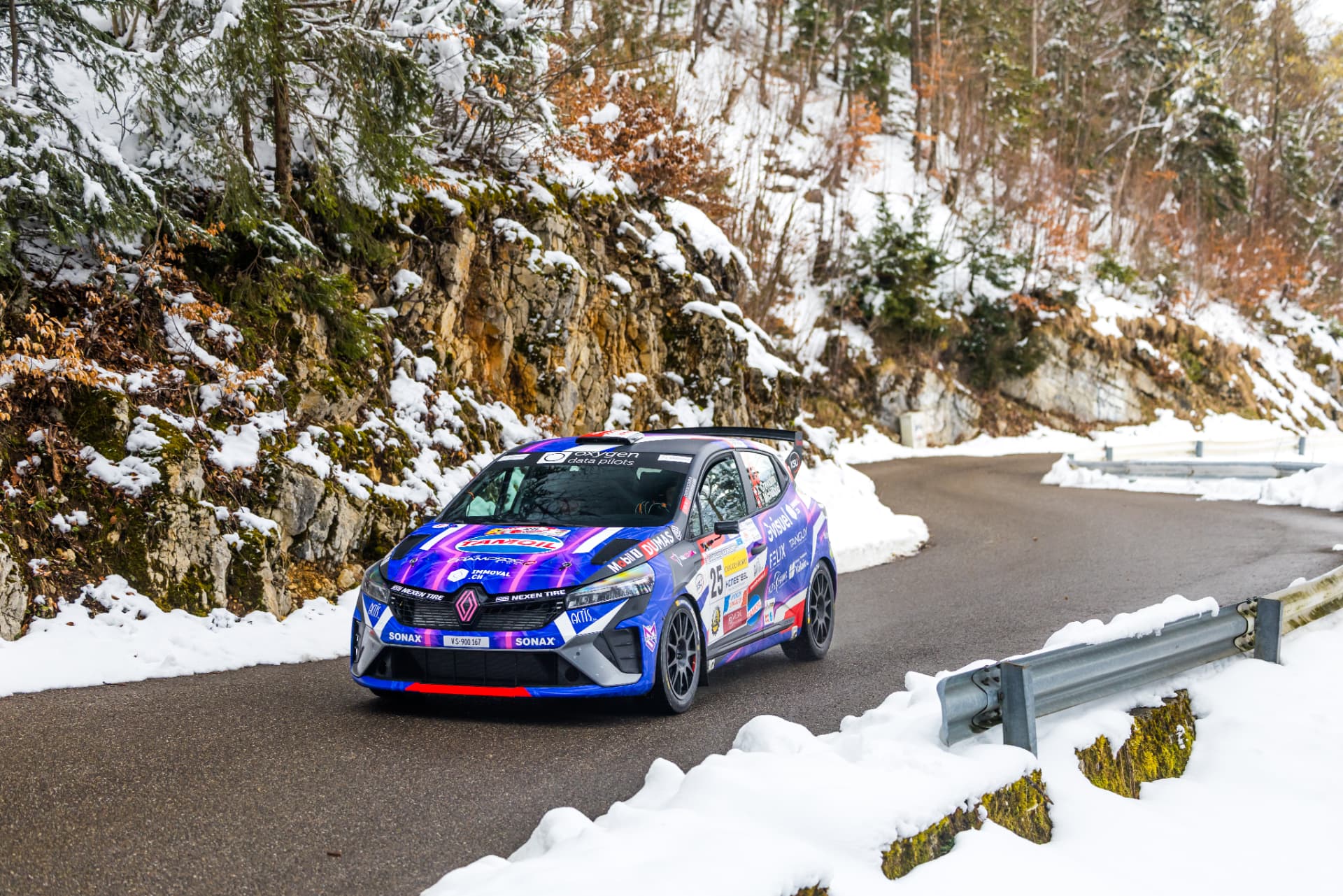 La Clio Rally3 n°25 en appui le long des glissières, décor hivernal jurassien